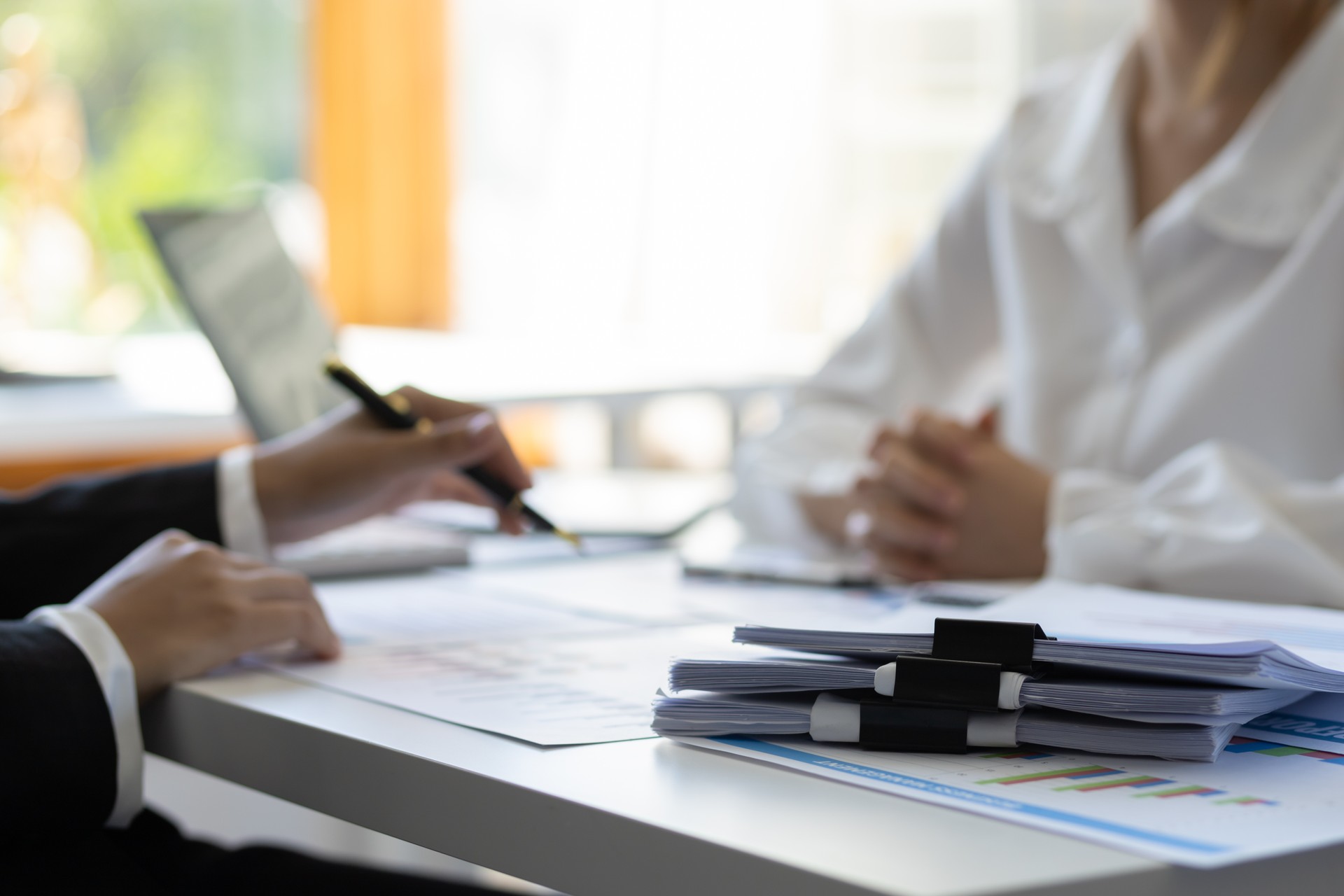 Financial advisor discussing business management planning with businesswoman in office.